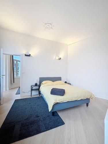 a bedroom with a bed and a blue rug at Cosy Apartment Uccle 3 in Brussels