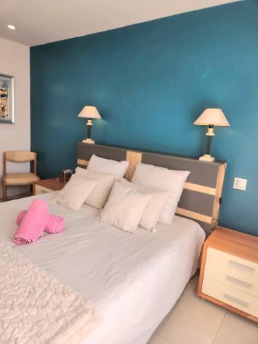 une chambre avec un grand lit blanc avec des oreillers roses dans l'établissement Domaine dans les Vignes, à Roquefort-la-Bédoule