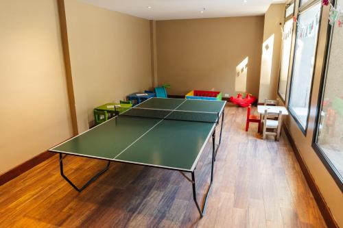 a ping pong table in a room with chairs at Loi Suites Chapelco Hotel in San Martín de los Andes