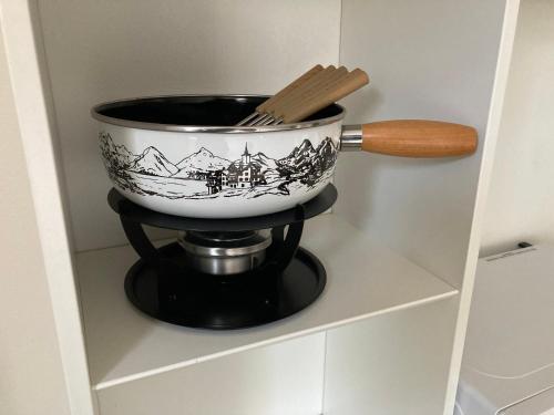 a pot on a stand with a wooden spoon at Chalet Wasserfall 3-Zimmerferienwohnung möbliert in Adelboden