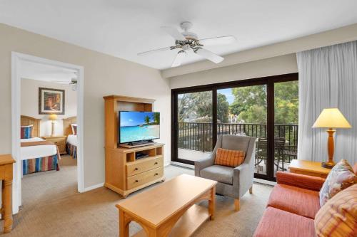a living room with a couch and a television and a bed at End Unit with Resort Views From Lanai in Naples