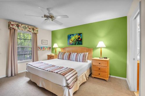 a bedroom with a bed and a green wall at End Unit with Resort Views From Lanai in Naples