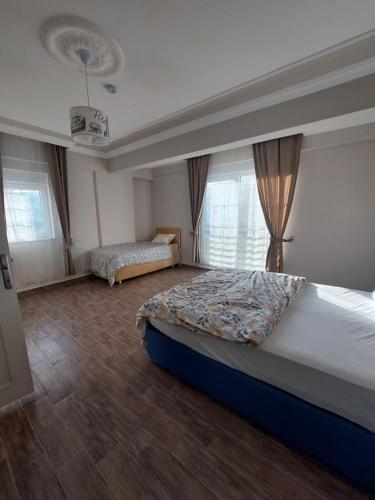 a bedroom with a large bed and two windows at villaLemoon in Belek