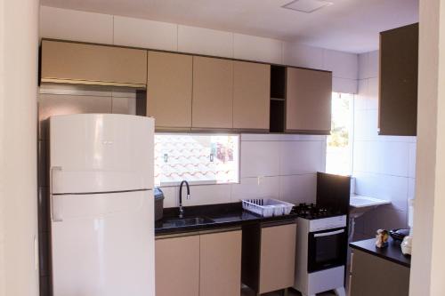 eine Küche mit einem weißen Kühlschrank und einer Spüle in der Unterkunft Apartamento de praia em Barra Grande in Maragogi