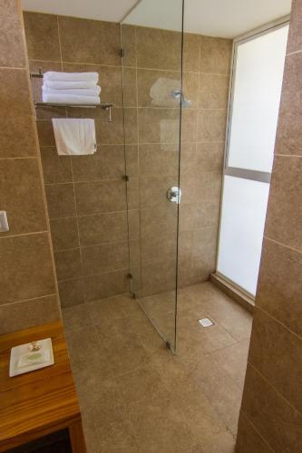 a shower with a glass door in a bathroom at Hotel 8 al Mar in Pichilemu