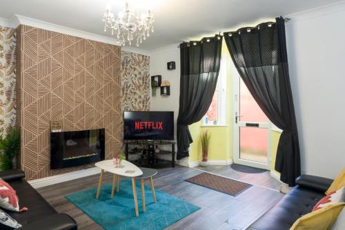 a living room with a couch and a fireplace at Pleasure beach apartment with garden in Skegness