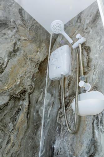 a shower in a bathroom with a stone wall at Pleasure beach apartment with garden in Skegness
