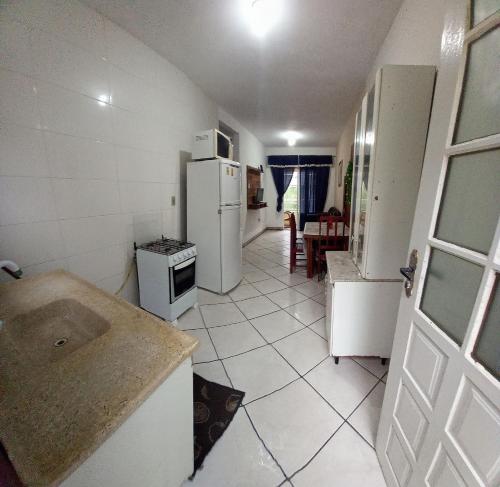 a small kitchen with a refrigerator and a table at Apartlaguna - 2 residenciais diferentes in Laguna