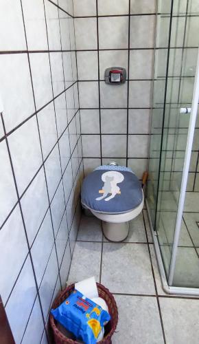 a bathroom with a toilet in a tiled room at Quarto compartilhado Costa Norte in Florianópolis