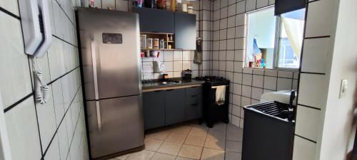 a kitchen with a stainless steel refrigerator and a sink at Quarto compartilhado Costa Norte in Florianópolis