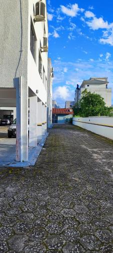 an empty street next to a white building at Quarto compartilhado Costa Norte in Florianópolis
