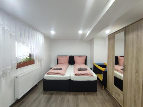 a bedroom with two beds with pink pillows at Ferienhaus Stani in Eschwege