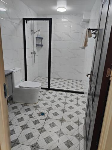 a bathroom with a toilet and a tiled floor at Happy Bargain Accommodation in Apia