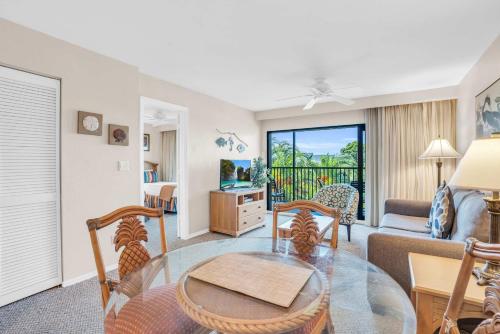 a living room with a glass table and chairs at 4th Floor Updated Condo in Naples