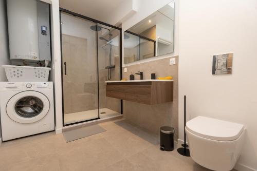 a bathroom with a toilet sink and a washing machine at Elégance en Luberon - 4 personnes - Central - Wifi in Apt