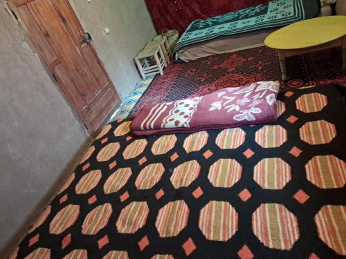 a room with a bed and a table and a door at Camp Sahara inspiration in Mhamid