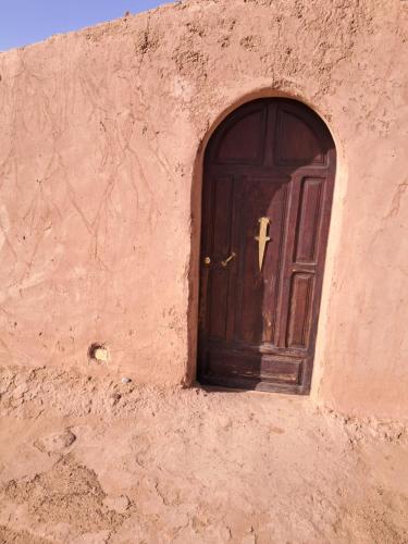 a brown door in the side of a building at Camp Sahara inspiration in Mhamid