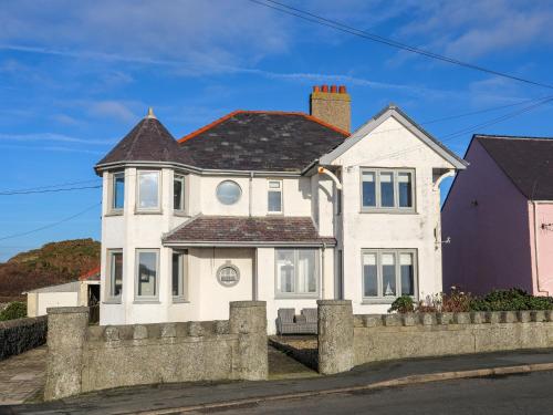 a white house with a fence in front of it at Min Y Mor Trearddur Bay in Trearddur