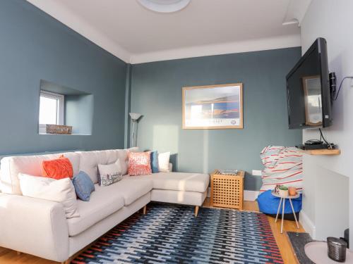 a living room with a white couch and blue walls at Min Y Mor Trearddur Bay in Trearddur