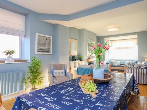 a blue living room with a table with fruit on it at Min Y Mor Trearddur Bay in Trearddur