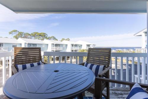 a blue table and chairs on a balcony with the ocean at Bay View 6 in Orange Beach