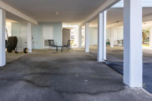 an empty garage with white columns and tables and chairs at Bay View 6 in Orange Beach