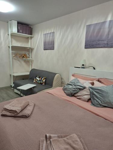 a bedroom with a large bed and a chair at Апартамент Квадратчето in Vratsa