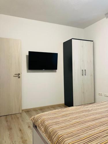 a bedroom with a bed and a tv on the wall at Apartments & Rooms Seaside in Kaštela