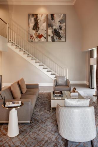 a living room with a couch and a staircase at Hotel Crescent Court in Dallas