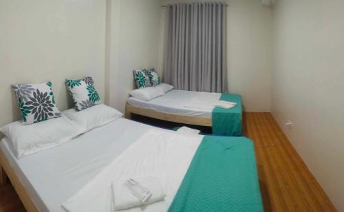 a small room with two beds and a window at Baden Powell Hostel in Baguio