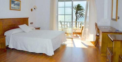 a bedroom with a white bed and a view of the ocean at Hotel Donde Caparrós in Carboneras