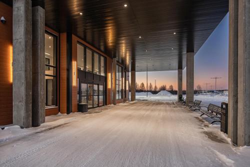 an empty building with benches in the snow at Le Boréal Abitibi Hôtel in Val-dʼOr