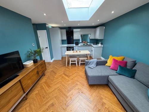 a living room with a couch and a tv at Streatham House - 2 Bedroom - Sleeps 6 - Free WiFi in Streatham Vale