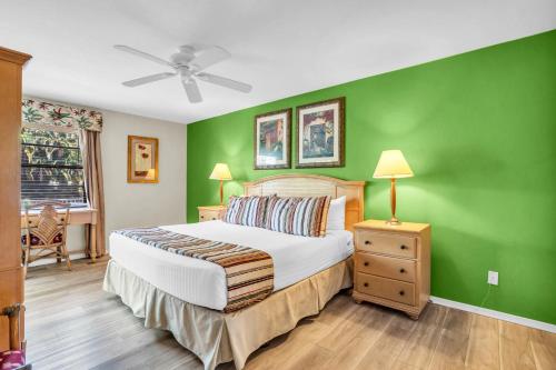 a bedroom with a bed with a green wall at First Floor Deluxe Condo in Naples