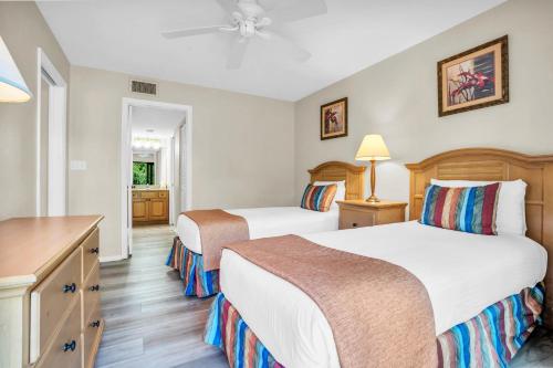 a hotel room with two beds and a desk at First Floor Deluxe Condo in Naples