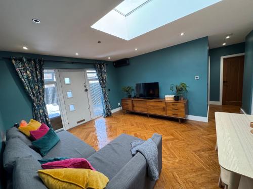 a living room with a couch and a tv at Streatham House - 2 Bedroom - Sleeps 6 - Free WiFi in Streatham Vale