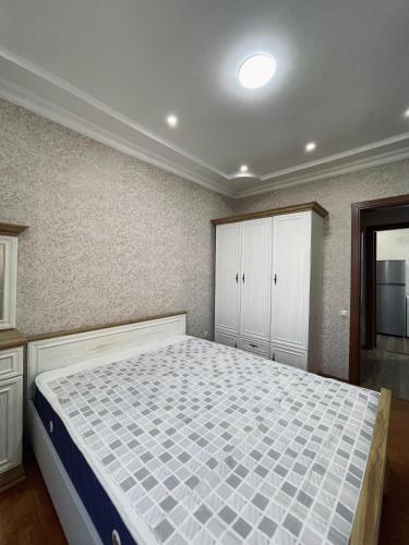 a bedroom with a large bed and white cabinets at Lucia Poti in Poti