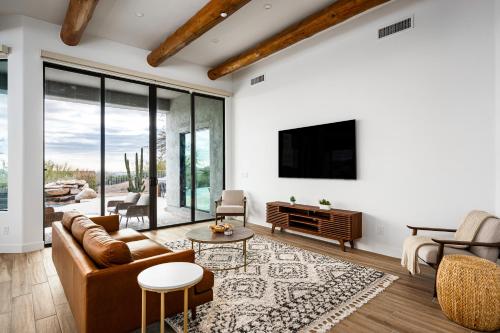 a living room with a couch and a tv at Mountain views swimming a private escape at Sonoran Serenity in Scottsdale