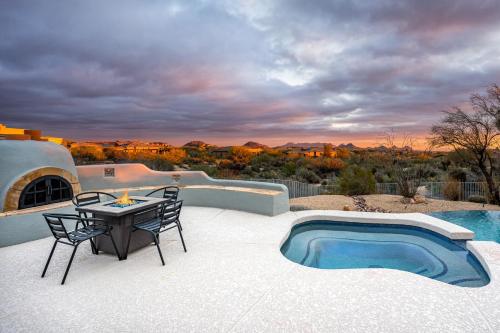 a patio with a table and chairs and a pool at Mountain views swimming a private escape at Sonoran Serenity in Scottsdale