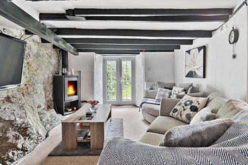 a living room with a couch and a tv at Shilla Mill - Just off the Beach in Polzeath