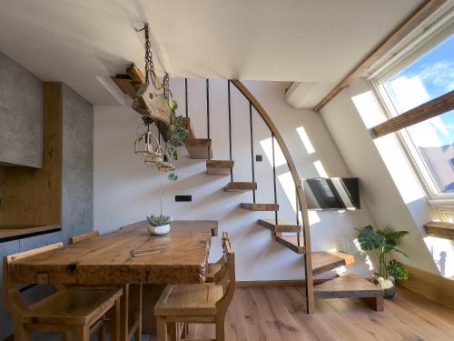 a dining room with a wooden table and stairs at Cozy Apartment Bovec in Bovec