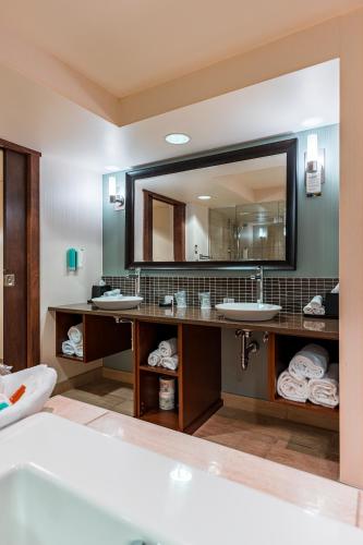 a bathroom with two sinks and a large mirror at Red Deer Resort & Casino in Red Deer
