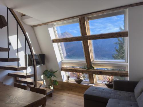 a living room with two large windows and a couch at Cozy Apartment Bovec in Bovec