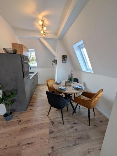 a kitchen and dining room with a table and chairs at Villa Baumhaus Apartments in Hamm