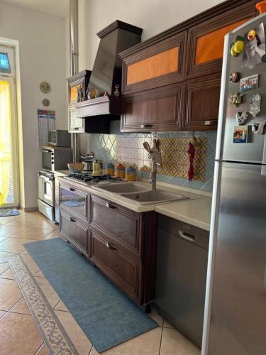 a kitchen with wooden cabinets and a stainless steel refrigerator at Casa Vacanze Casa Meme in Boscotrecase