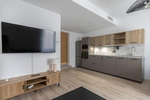 une grande cuisine avec une télévision à écran plat sur un mur dans l'établissement Elégance en Luberon - 4 personnes - Central - Wifi, à Apt