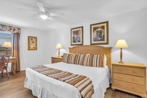 1 dormitorio con 1 cama, 2 lámparas y 1 silla en Deluxe Condo with Lake Views, en Naples