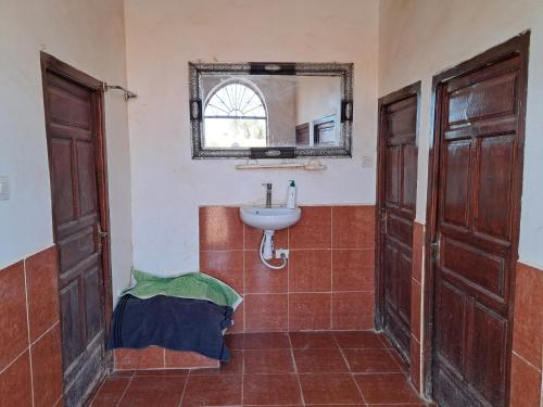 a bathroom with a sink and a mirror at Camp Sahara inspiration in Mhamid