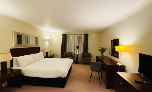 a hotel room with a bed and a desk at Hustyns Hotel in Wadebridge