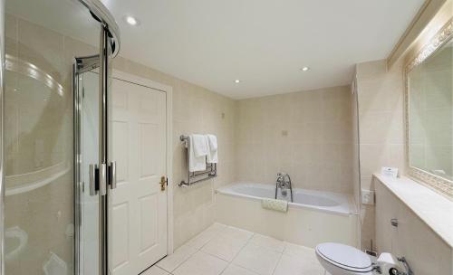a bathroom with a shower and a toilet and a tub at Hustyns Hotel in Wadebridge